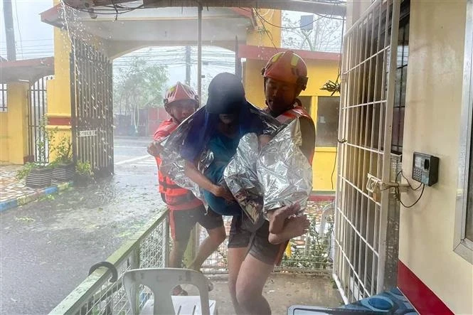 Les secouristes évacuent un habitant d'une zone inondée causée par le typhon Ewiniar dans la province de Quezon aux Philippines, le 26 mai. (Photo : AFP/VNA)