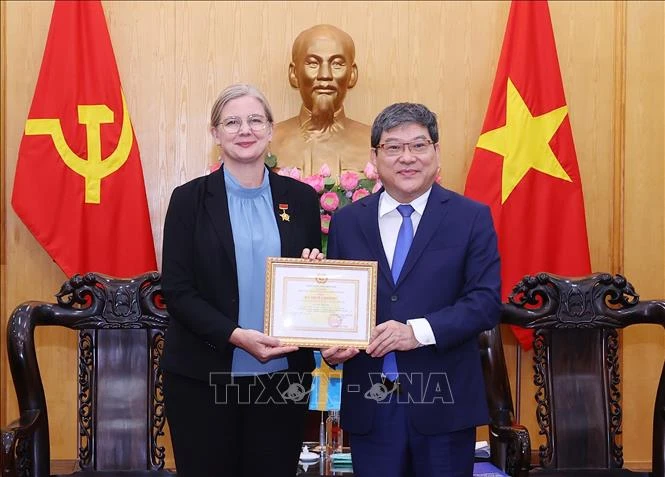 L'ambassadrice de Suède au Vietnam reçoit un insigne pour sa contribution à l'enseignement de la théorie politique. Photo : VNA