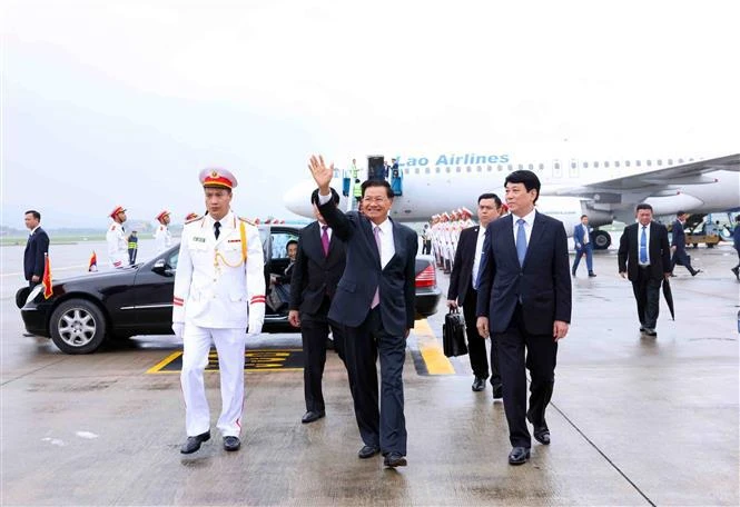 Le secrétaire général du Comité central du Parti populaire révolutionnaire lao (PPRL) et président du Laos, Thongloun Sisoulith, son épouse et une délégation lao de haut rang ont été accueillis à l'aéroport international de Nôi Bài. Photo : 