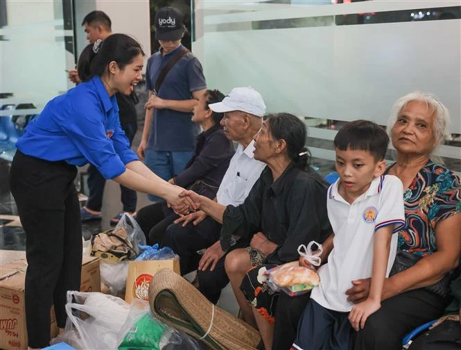 Des jeunes bénévoles aident les habitants du quartier de Yen Phu, à Hanoi, à se rendre dans un endroit plus sûr. (Photo : VNA)