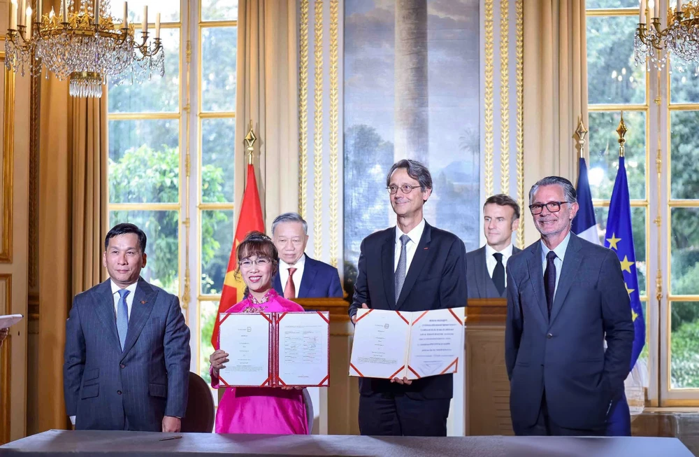 La Dr Nguyen Thi Phuong Thao, présidente de Vietjet, Dinh Viet Phuong, directeur général de Vietjet (premier, gauche), Olivier Andries, Président-directeur général de Safran (2 à droite) et Gaël Méheust, président-directeur général de CFM International (droite) lors de la cérémonie signature en présence du digigeant To Lam et du président français Emmanuel Macron. Photo