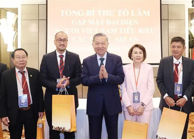 Le secrétaire général du Comité central du Parti communiste du Vietnam, To Lam (au centre), offre des cadeaux à des Vietnamiens exceptionnels vivant dans les pays de l'ASEAN. (Photo : VNA)