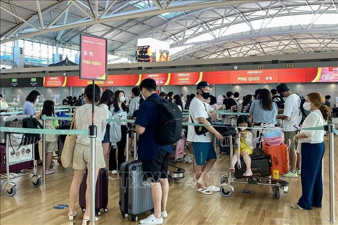 游客在韩国仁川国际机场排队办理飞往越南富国岛的登机手续。图自越通社