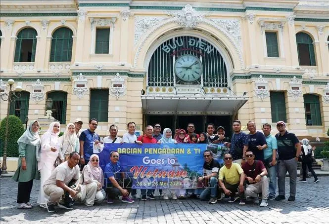 国际游客在著名旅游目的地——胡志明市邮局打卡。图自越通社