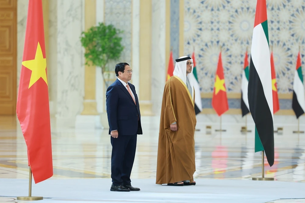 Prime Minister Pham Minh Chinh (L) and Vice President of the United Arab Emirates (UAE) Sheikh Mansour bin Zayed Al Nahyan at the official welcome ceremony for the Vietnamese leader. (Photo: VNA)