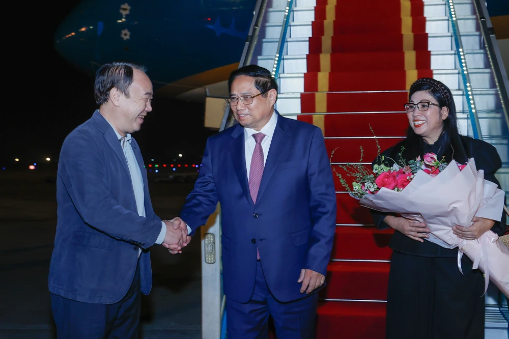 Prime Minister Pham Minh Chinh (C) and his spouse are welcomed by Vice Chairman of the Government Office Nguyen Sy Hiep at the Noi Bai International Airport. (Photo: VGP)