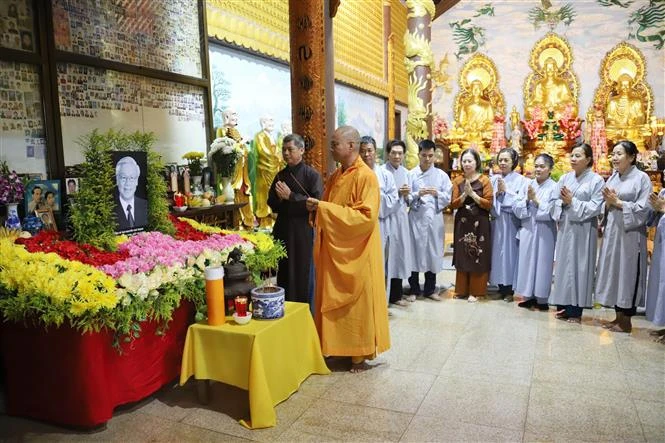 Au Laos, des moines et des bouddhistes brûlent de l'encens pour commémorer ensemble le secrétaire général Nguyen Phu Trong. Photo: VNA