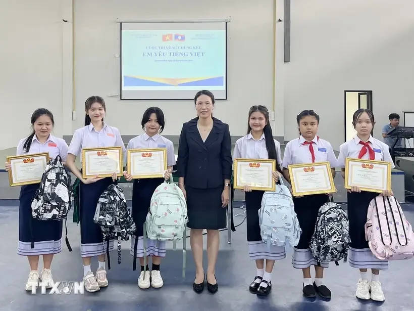 La consule générale du Vietnam à Savannakhet, Dang Thi Hai Tam, et des élèves lors du concours "J'aime le vietnamien". Photo: VNA