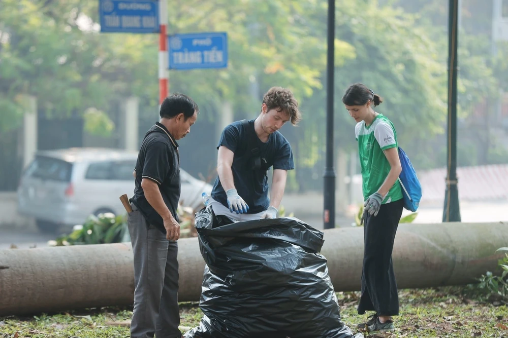 Des bénévoles ramassent les déchets dans le jardin Bac Co dans l'arrondissement de Hoan Kiem. Photo: VNA