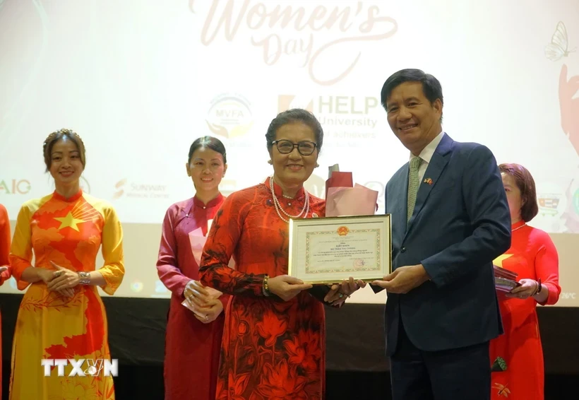 L'ambassadeur du Vietnam en Malaisie, Dinh Ngoc Linh, remis un certificat de mérite à Mme Tran Thi Chang, présidente de l'Association d'amitié Malaisie-Vietnam, lors de la célébration. Photo : VNA