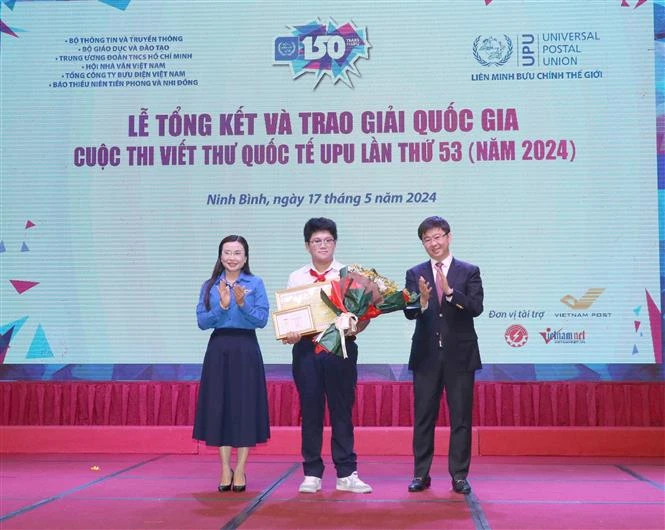 Nguyen Do Quang Minh (centre), a 9th grader in the central city of Da Nang, recieves the first prize at the awarding ceremony in Ninh Binh province. (Photo: VNA)