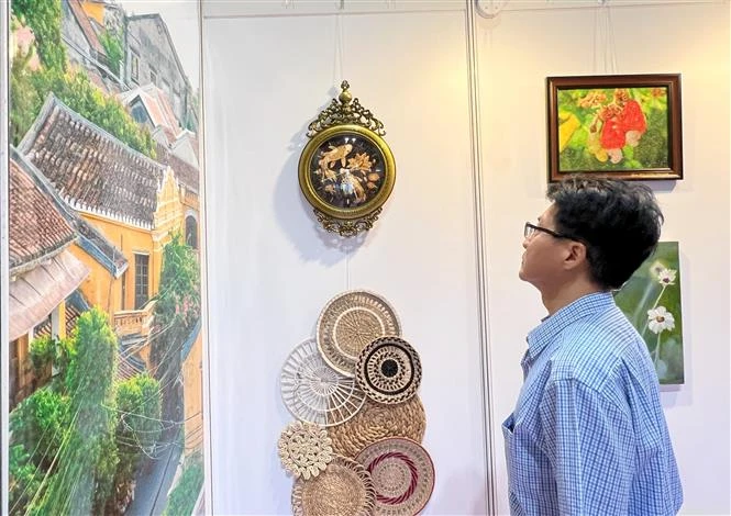 A visitor to the Hong Kong art expo watches Vietnamese products on display. (Photo: VNA)