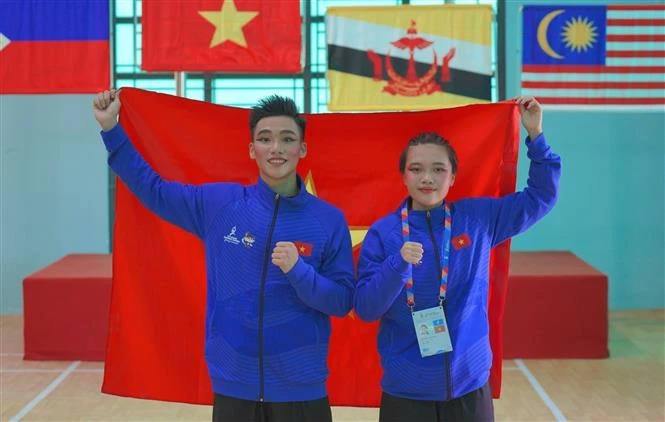 Pencak Silat athletes - Hoang Linh Dan (right) and Nguyen Thanh Long - win two gold medals in Seni events (performance) at the ongoing 13th ASEAN School Games (ASG) in the central city of Da Nang. (Photo: VNA)