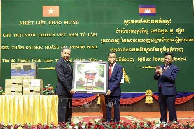 President To Lam (left) gives a gift to the Royal University of Phnom Penh. (Photo: VNA)