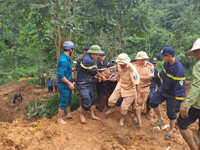 Rescuers find a victim after a mini bus is buried by a landslides in the mountainous province of Ha Giang on July 13. (Photo: VNA)