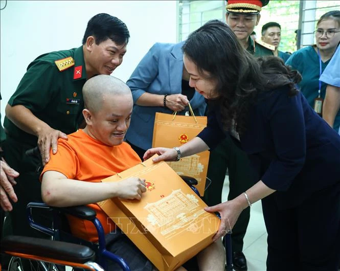 Vice President Vo Thi Anh Xuan presents a gift to an AO victim at the Center for the Care, Nursing and Treatment of AO/Dioxin Victims in Ba Vi District, Hanoi. (Photo: VNA)