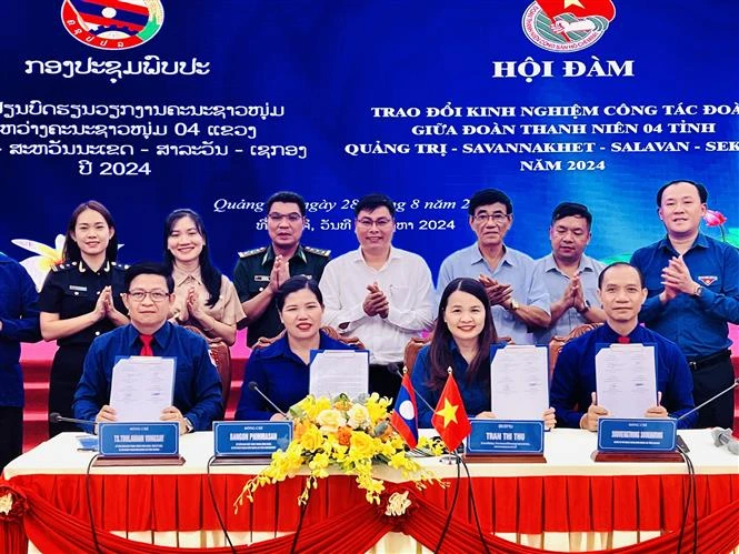 The youth unions of Quang Tri province and three Lao provinces - Savannakhet, Salavan and Sekong- sign a joint message of the friendship programme on August 28. (Photo: VNA)