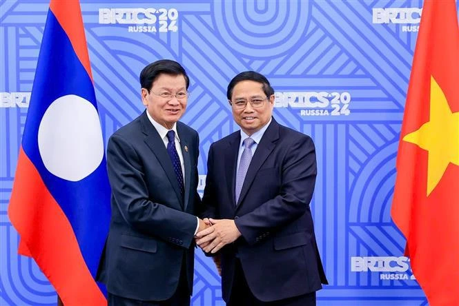 Prime Minister Pham Minh Chinh (R) and Lao Party General Secretary and State President Thongloun Sisoulith in Kazan, Russia, on October 23 when attending the expanded BRICS Summit. (Photo: VNA)