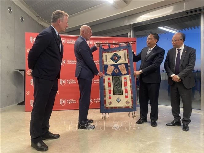 Deputy Secretary of the Party Committee of the northern moutainous province of Lao Cai Hoang Giang (second, R) presents souvenirs to a leader of the Nouvelle Aquitaine region. (Photo: VNA)