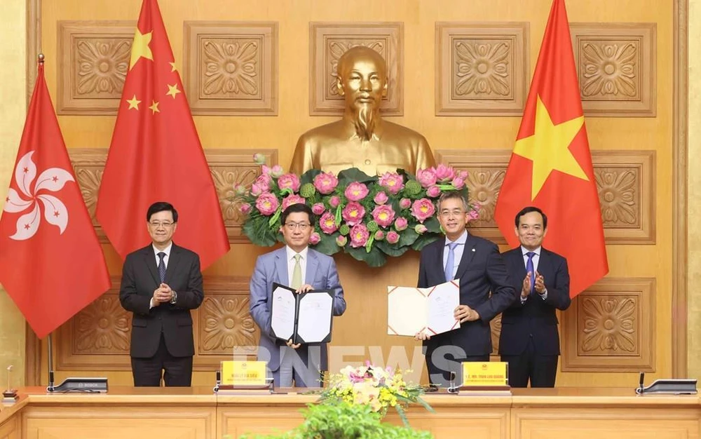 Deputy Prime Minister Tran Luu Quang (R) and Chief Executive of the Hong Kong Special Administrative Region (China) Lee Ka-chiu (L) witness the exchange of the MoU between Vietnam Airlines and the Hong Kong International Airport (HKIA). (Photo: VNA)