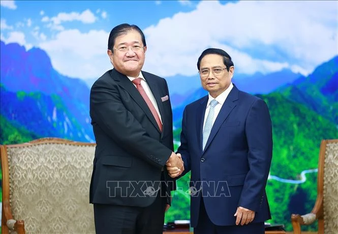 Prime Minister Pham Minh Chinh (R) shakes hands with Chairman of Mitsui & Co., Ltd of Japan Tatsuo Yasunaga (Photo: VNA)