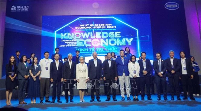 Prof. Klaus Schwab, and delegates pose for a group photo at the talkshow. (Photo: VNA)