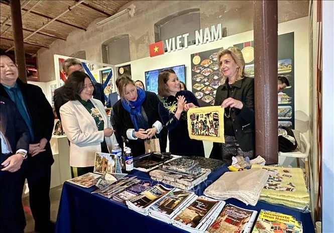 In Vietnam's exhibition area, visitors has a chance to print Dong Ho folk woodcut paintings. (Photo: VNA)