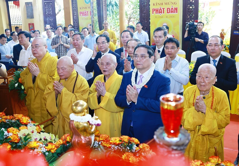Prime Minister Pham Minh Chinh (second from the right, first row) and Vietnam Buddhist Sangha's dignitaries perform the traditional rituals of bathing the Buddha. (Photo: VNA)