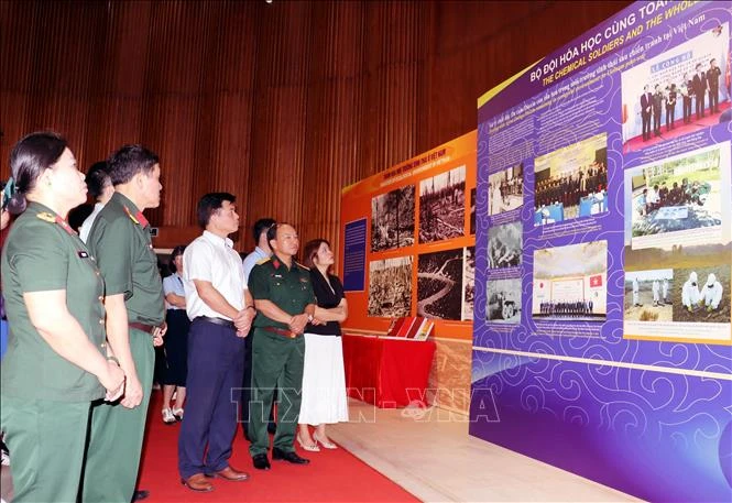 Visitors look at photos at the exhibition (Photo: VNA)