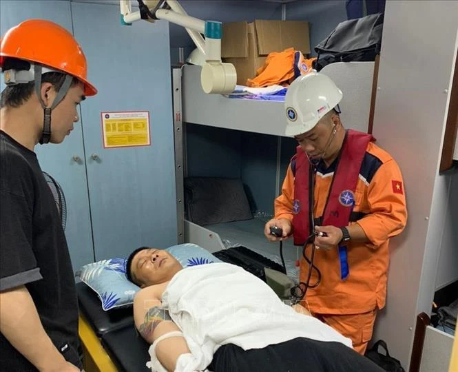 Vietnam Maritime Research and Rescue Coordination Centre’s staff provide check-ups for the Chinese sailor before brought him ashore for emergency treatment. (Photo: VNA)