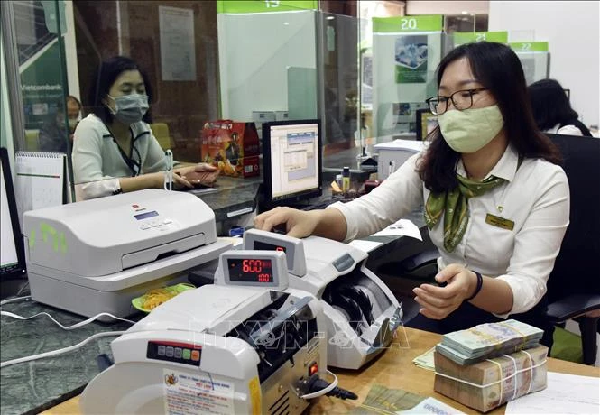 Customers make transactions at Vietcombank's head office in Hanoi. (Photo: VNA)