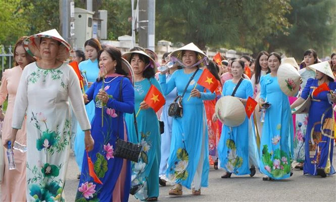同塔省5500名妇女身穿传统奥黛参加“闪耀莲花”游行。图自越通社