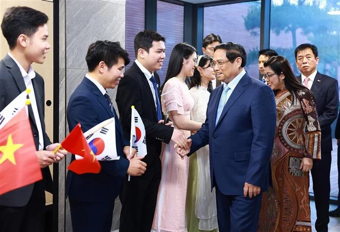越南政府总理范明政和夫人与大使馆工作人员和侨胞们亲切握手。图自越通社