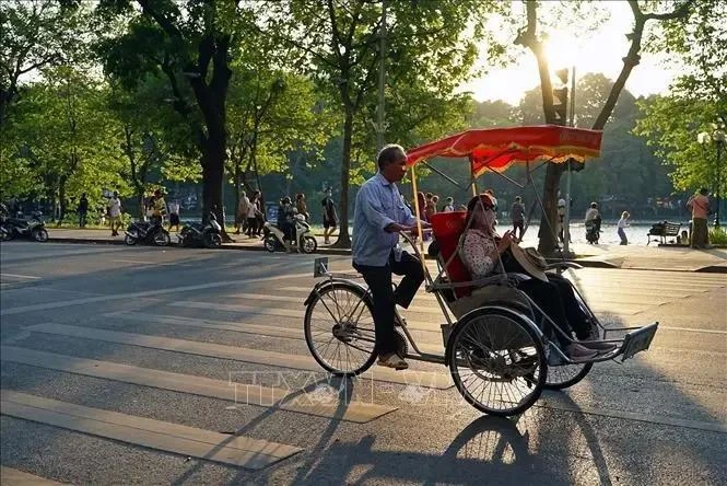 游客乘坐三轮车在还剑湖周边游玩。图自越通社