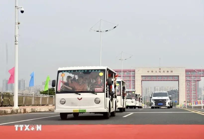 载着出境游客的电动汽车在北仑二桥通行。图自越通社