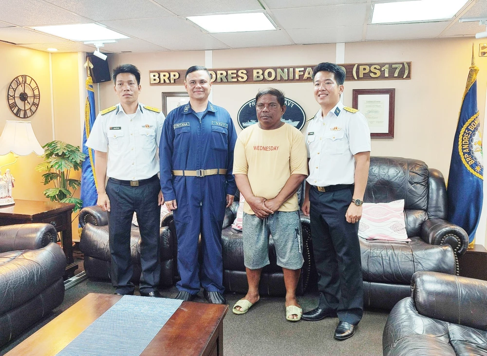 Des cadres du navire 412 et le pêcheur philippin Allan Maglangit (maillot jaune). Photo: VNA