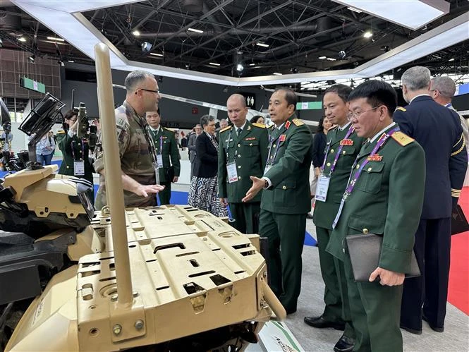 Des représentants du ministère vietnamien de la Défense visitent un espace d'exposition. Photo: VNA