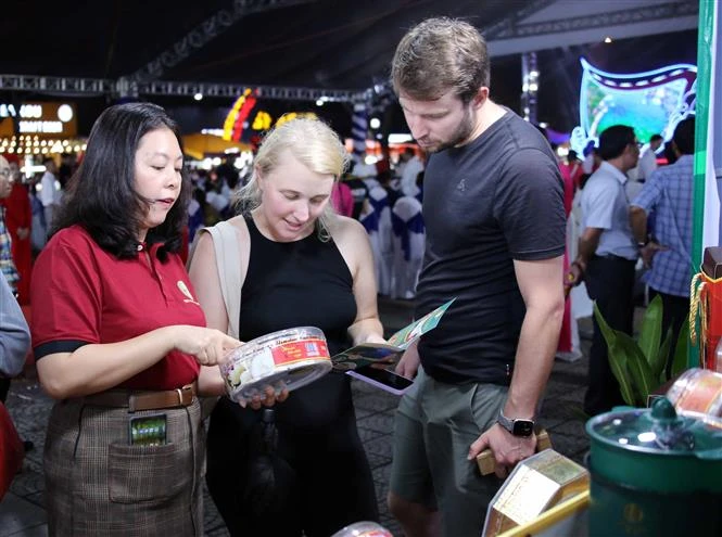 Des touristes se renseignent sur des produits de nids de salanganes de la province de Ninh Thuan lors de l'événement. Photo : VNA