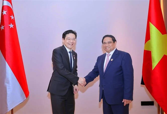 Vietnamese Prime Minister Pham Minh Chinh (right) and his Singaporean counterpart Lawrence Wong meets in Vientiane, Laos, on October 9. (Photo: VNA)