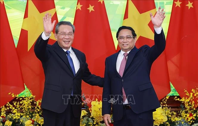 Prime Minister Pham Minh Chinh (right) and Chinese Premier Li Qiang pose for a photo before their talks in Hanoi. (Photo: VNA)