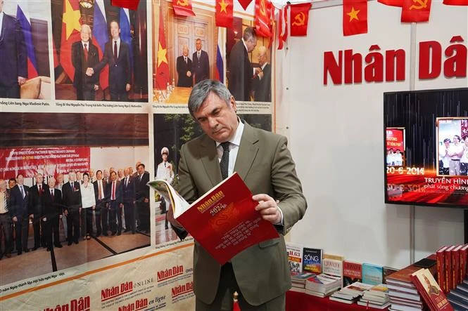 Vyacheslav Kalganov, Vice Chairman of the Committee for External Relations of Saint Petersburg visits the stall of Nhan Dan (People) in Saint Petersburg Int’l Book Fair (Photo: VNA)