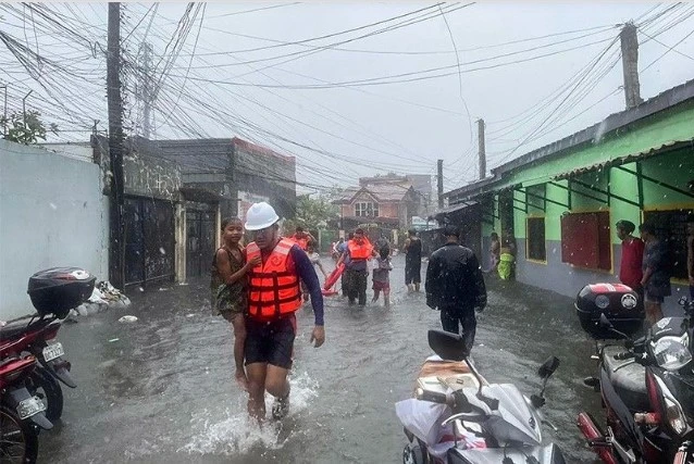 Children are evacuated from a flooded area by coast guard personnel in Lucena, Quezon province, the Philippines, amid heavy rain brought by tropical storm Ewiniar. (Photo: philstar.com) 