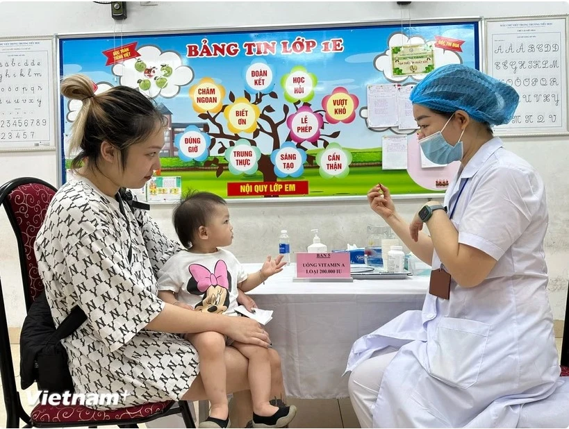 A child receives a free high-dose vitamin A pill. (Photo: VNA)