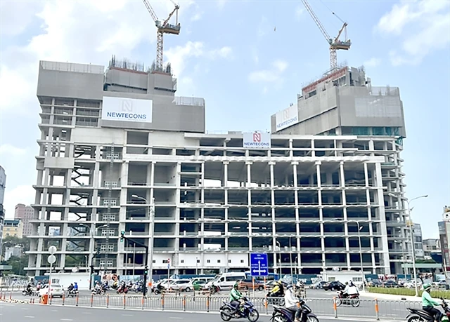 Construction of a building near Ben Thanh Market by Viva Land, a subsidiary of Van Thinh Phat Group, stalled at the end of 2022 following the arrest of its chairwoman Truong My Lan. Real estate developers are struggling to meet repayment obligations due to a sluggish market. (Photo: vietnamnews.vn)