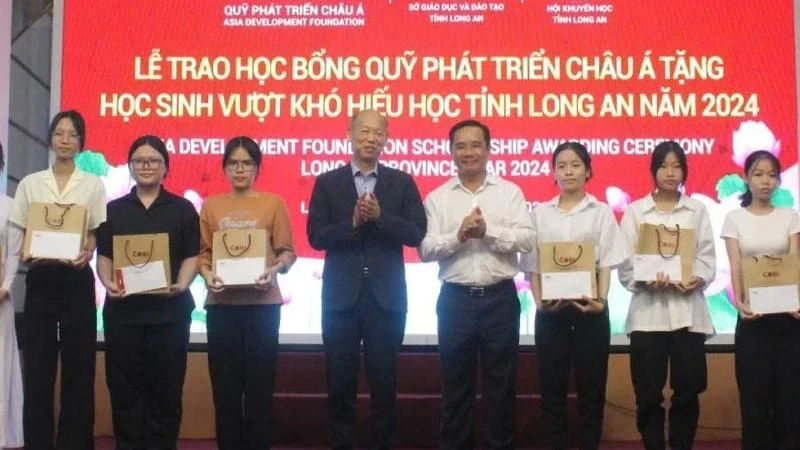 Nguyen Van Duoc, Secretary of the provincial Party Committee and Chairman of the Long An People's Council; Kim Joon Il, Chairman of COBI Group and ADF; and students at the ceremony. (Photo: VNA)