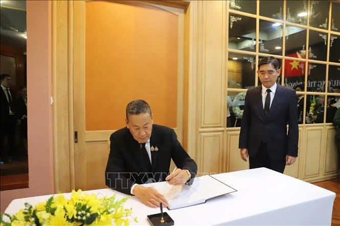 Le Premier ministre thaïlandais, Srettha Thavisin, écrit dans le registre de condoléances. Photo: VNA