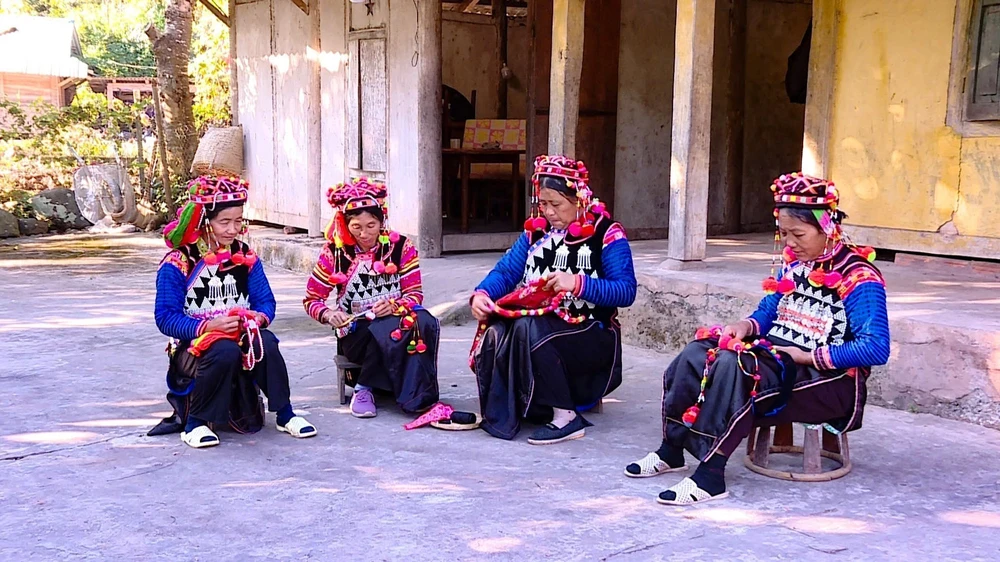 Des femmes Ha Nhi préparent des costumes pour le Têt traditionnel. Photo: VNA