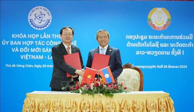 Los dos ministros intercambian documentos de la primera reunión del Comité de cooperación en Tecnología e Innovación Vietnam – Laos. (Fuente: VNA)