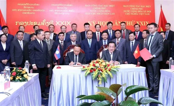 El viceministro de Defensa y jefe del grupo de trabajo vietnamita, el teniente general Vo Minh Luong (derecha), y el viceministro de Defensa y jefe del grupo de trabajo de Laos, el teniente general Thongloi Silivong, firman el acta de la reunión. (Foto: VNA)