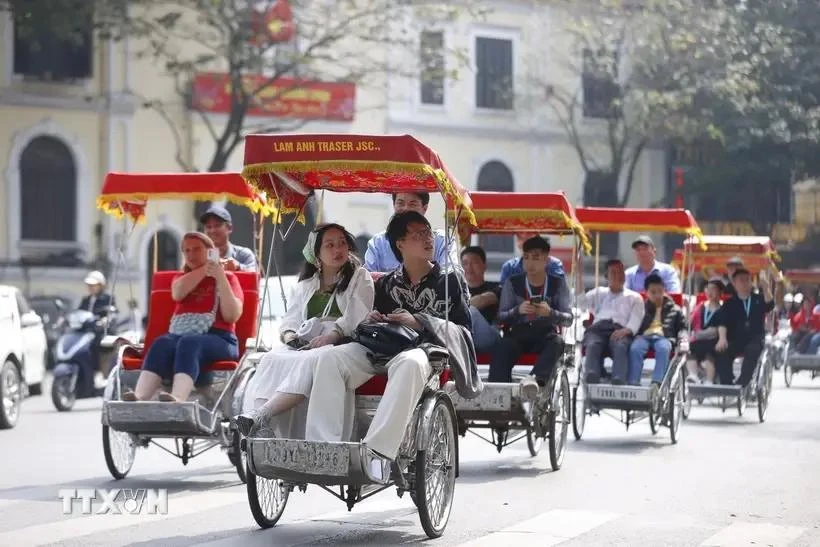 Los turistas pasean por el lago Hoan Kiem en ciclos (Fuente: VNA)